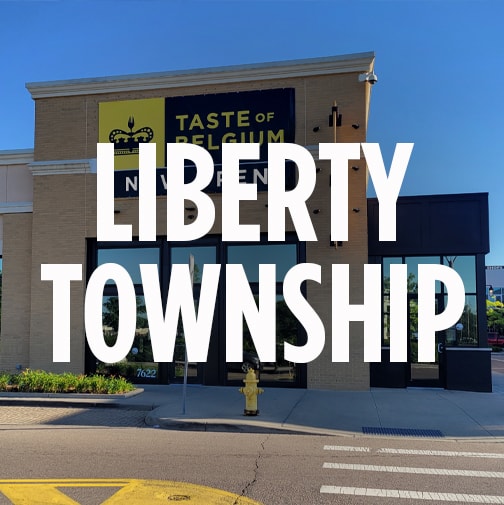 the storefront of taste of belgium's location in liberty township, ohio. The words "LIBERTY TOWNSHIP" is overlaid in bold white letters